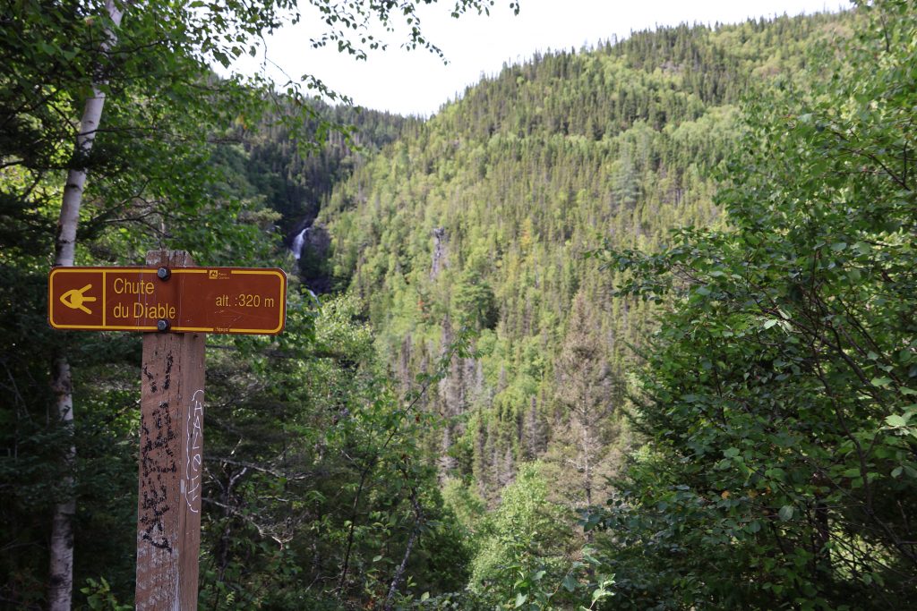 Hinweisschild vor einem Wasserfall